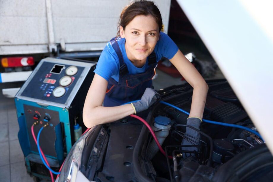 Mechanik pracuje przy naprawie klimatyzacji samochodowej.