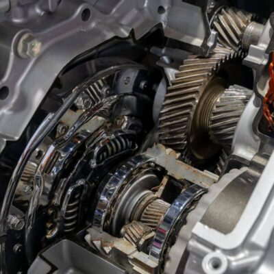 Widoczna jest szczegółowa struktura mechaniczna podczas naprawy skrzyni biegów.