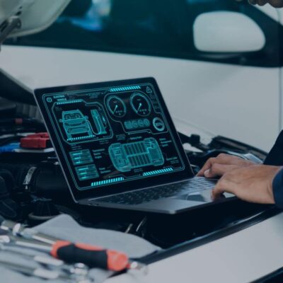Mechanik korzysta z laptopa, aby przeprowadzić diagnostykę komputerową silników w samochodzie.