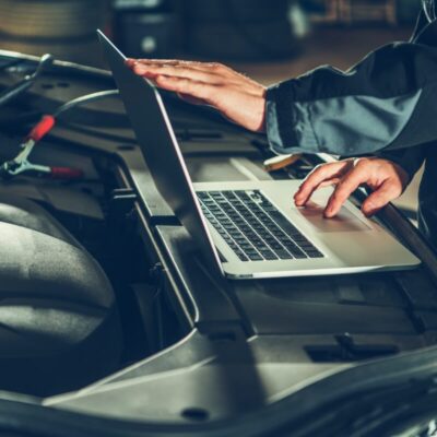 Mechanik przeprowadza diagnostykę silnika przy użyciu laptopa.