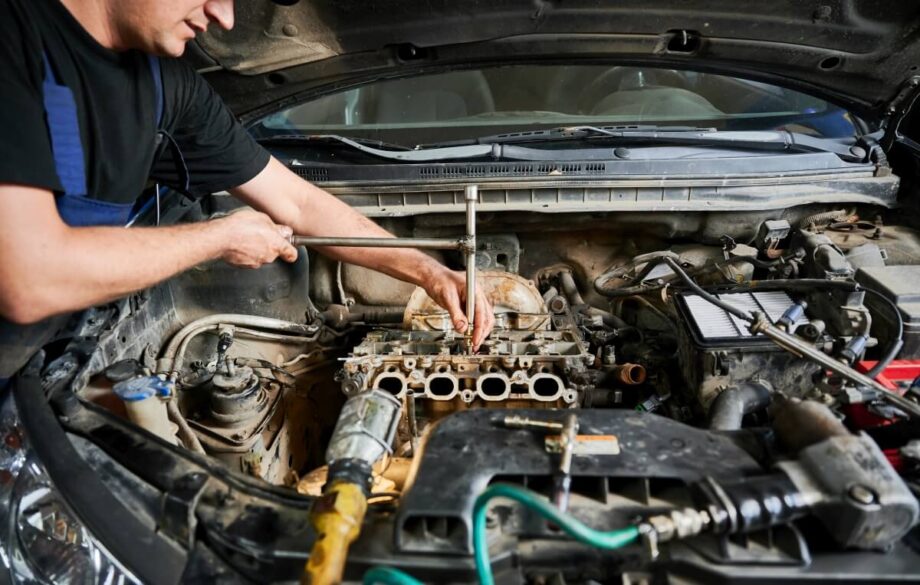 Mechanika samochodowa: mężczyzna pracuje przy silniku samochodu.
