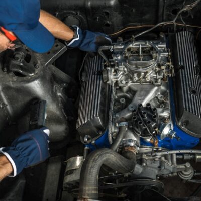 Mechanika samochodowa: mężczyzna naprawia silnik pojazdu.