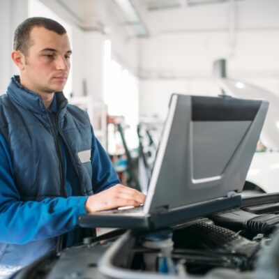 Mechanik przeprowadza diagnostykę silników za pomocą laptopa.