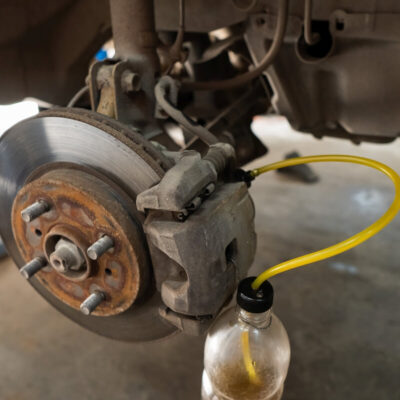 Zbliżenie na hamulec samochodowy podczas serwisu przedstawiające naprawę hamulców.